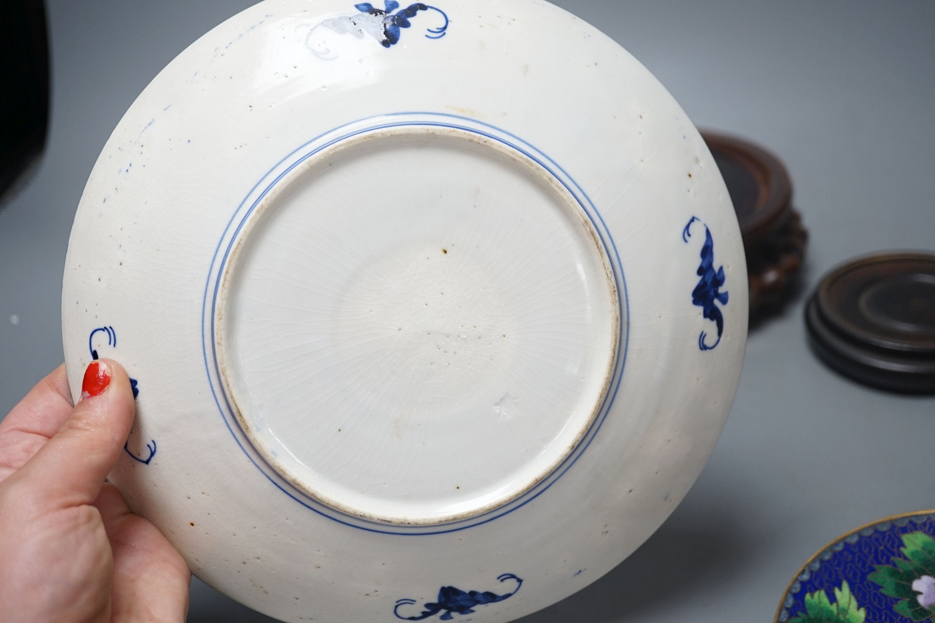 A Continental porcelain jam pot, 15cm tall, and cover with stand, together with 2 Chinese hardwood stands, enamelled plate and another (7)